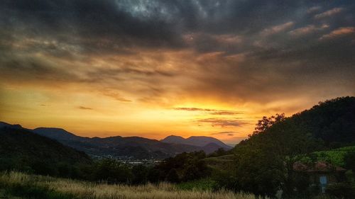 Scenic view of silhouette mountains against orange sky