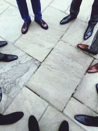 Low section of people standing on tiled floor