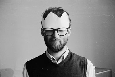 Portrait of man wearing paper crown and glasses