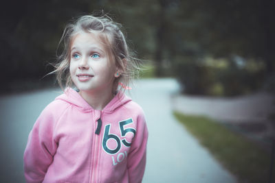 Portrait of cute girl with pink standing outdoors