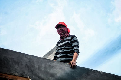 Low angle view of man standing against wall