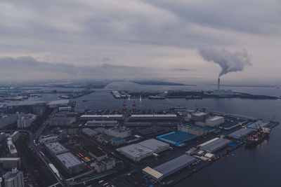 High angle view of cityscape by sea against sky