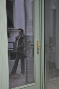 Woman standing by window in building