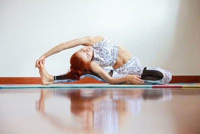 Full length of young woman exercising at home