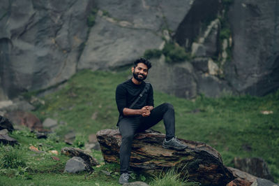 Portrait of man sitting on rock