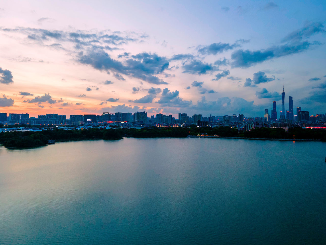 CITY BY RIVER AGAINST SKY AT SUNSET