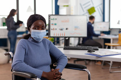 Portrait of businesswoman wearing mask at office