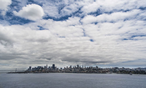 Scenic view of sea by buildings against sky