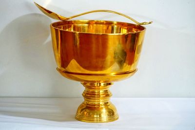 Close-up of gold container and spoon on table