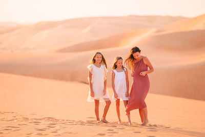 Woman standing on sand dune in desert