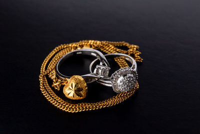 High angle view of wedding rings on table against black background