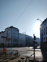 Bicycles on street in city against clear sky