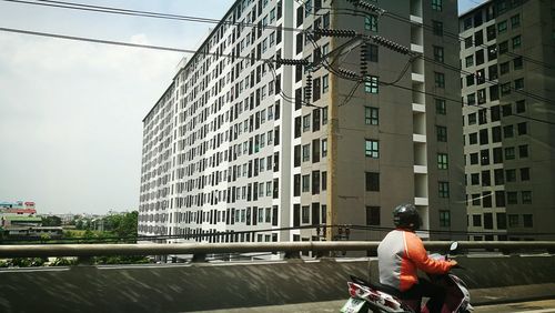 Rear view of man riding bicycle in city