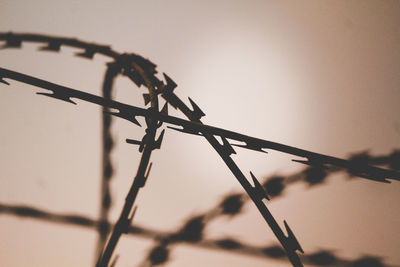 Low angle view of barbed wire against clear sky