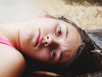 Close-up portrait of girl lying outdoors