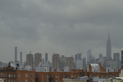 View of cityscape against cloudy sky