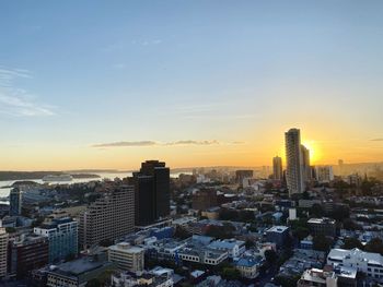 Aerial view of buildings in city at sunset