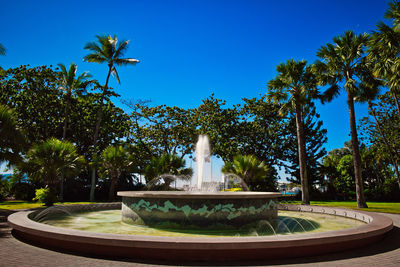 Fountain in park against clear blue sky