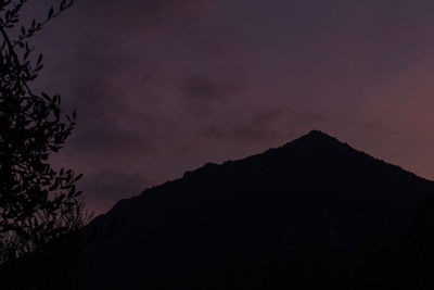 Low angle view of silhouette mountain against sky at sunset