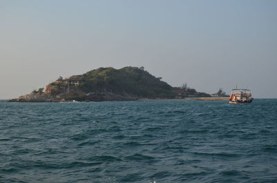 Boat sailing in sea against clear sky