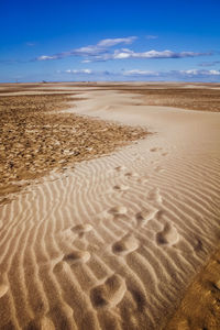 Sand dunes in desert against sky