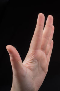 Close-up of human hand against black background