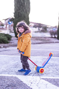 5 year old caucasian boy rides scooter.