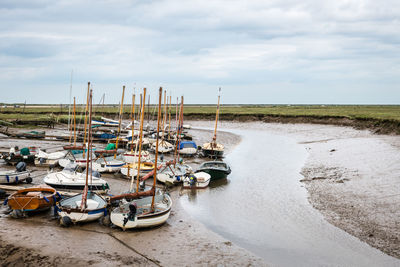 Boats moored on beach against sky