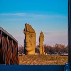 Statues against blue sky during sunset