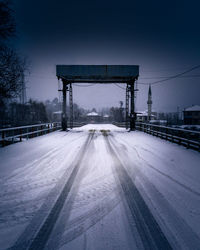 Empty snowy  road against clear sky