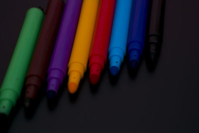Close-up of colored pencils on table against black background