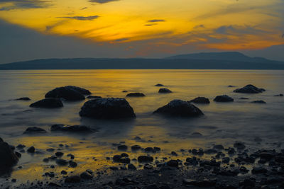 Rocks on the beach during sunrise in banyuwangi, indonesia.