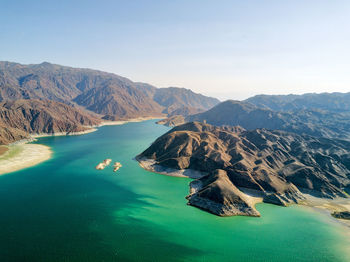 Scenic view of sea and mountains against clear sky