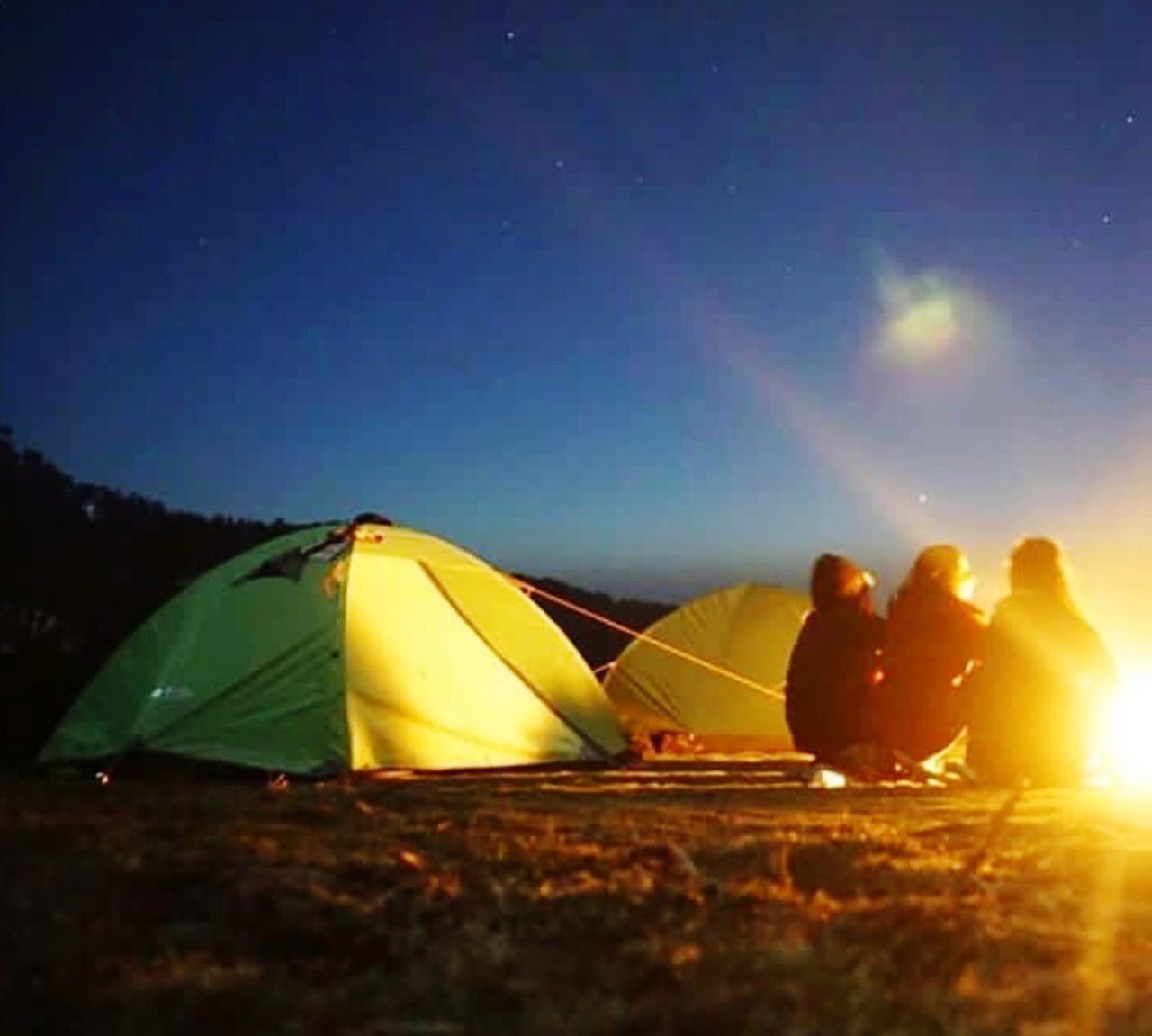 GROUP OF PEOPLE SITTING ON TENT