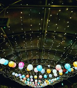 Low angle view of illuminated lights hanging at night