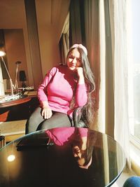 Portrait of smiling young woman sitting at home