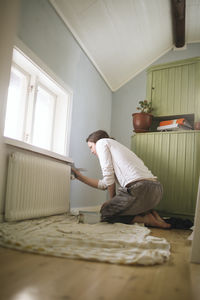 Woman painting wall at home  barefoot