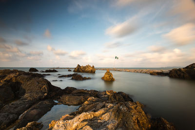 Rocks on sea against sky during sunset