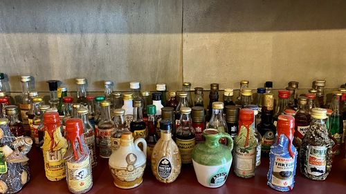 Close-up of wine bottles on shelf against wall