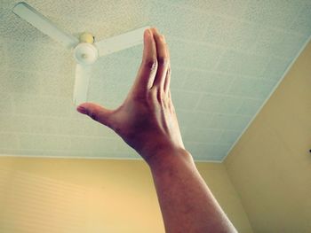 Close-up of man hand on wall at home