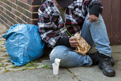 Homeless man sitting on footpath