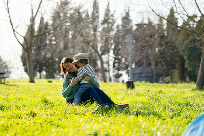 Rear view of couple sitting on field