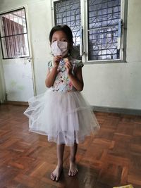 Girl wearing mask standing at home