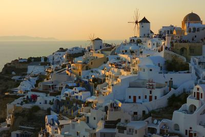 High angle view of townscape by sea against sky during sunset
