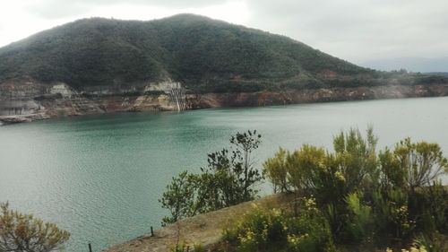 Scenic view of lake by mountains against sky