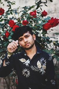 Portrait of young man standing against plants