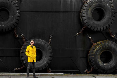 Man standing against tires in city