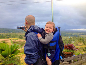 Full length of man photographing at camera against sky