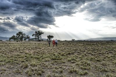 Scenic view of grassy field against cloudy sky