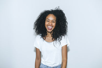 Portrait of laughing young woman sticking out tongue